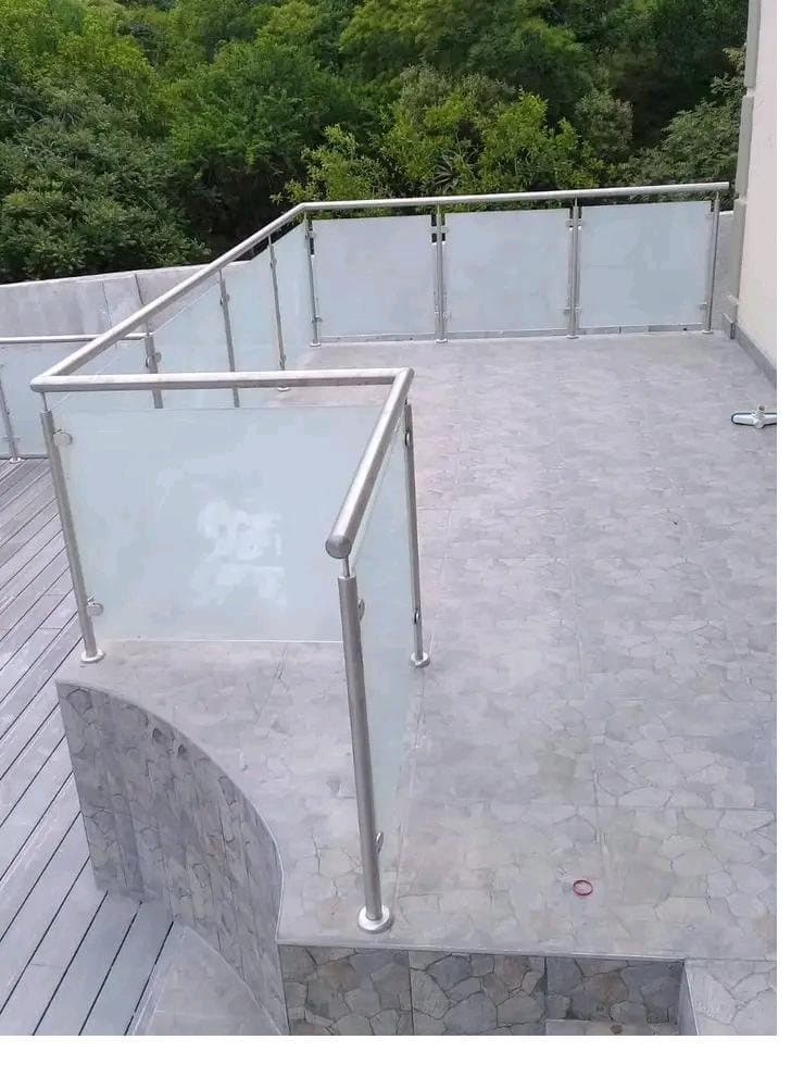 Frosted glass balustrade with round stainless steel posts on an outdoor terrace
