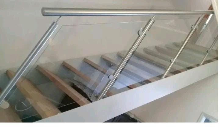 Glass balustrade with stainless steel handrail on a timber staircase